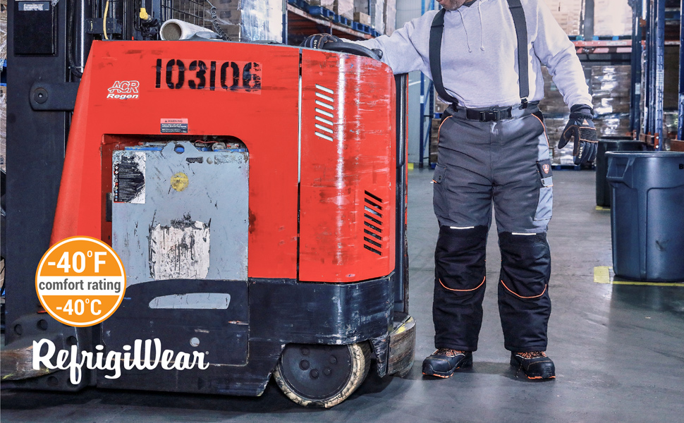 Man wearing PolarForce Pants in a Freezer warehouse standing next to a forklift.