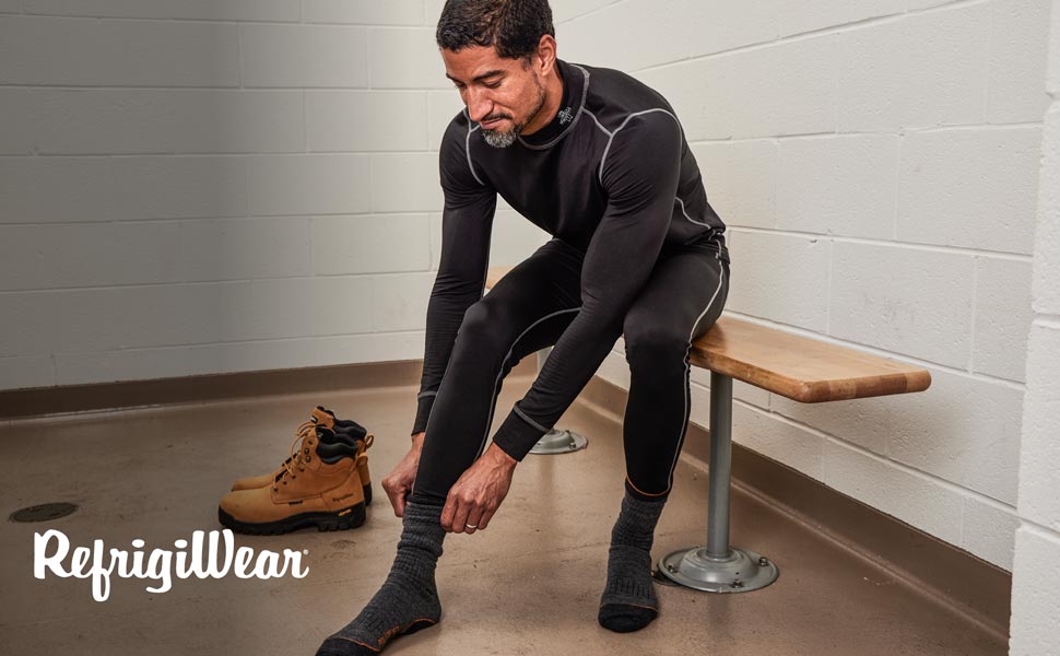 Man in locker room putting on socks wearing RefrigiWear's Lightweight Base Layers